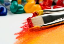 Close up of paint and paint brushes on white canvas