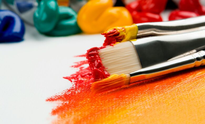 Close up of paint and paint brushes on white canvas