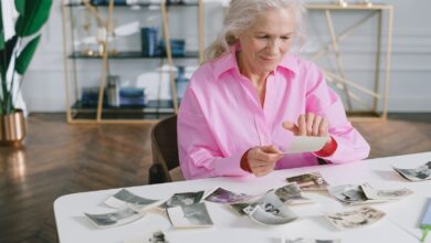 An older woman looking through old family photographs at home